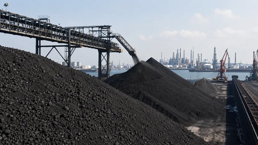 Coal stockpiles and a ship-loading conveyor at an export terminal